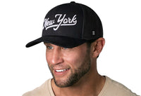 New York City White Script Trucker Hat  |  Black New York Snapback